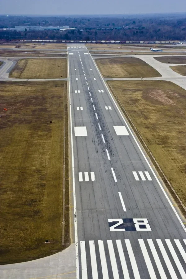 An airport runway stretches toward the horizon under clear skies.