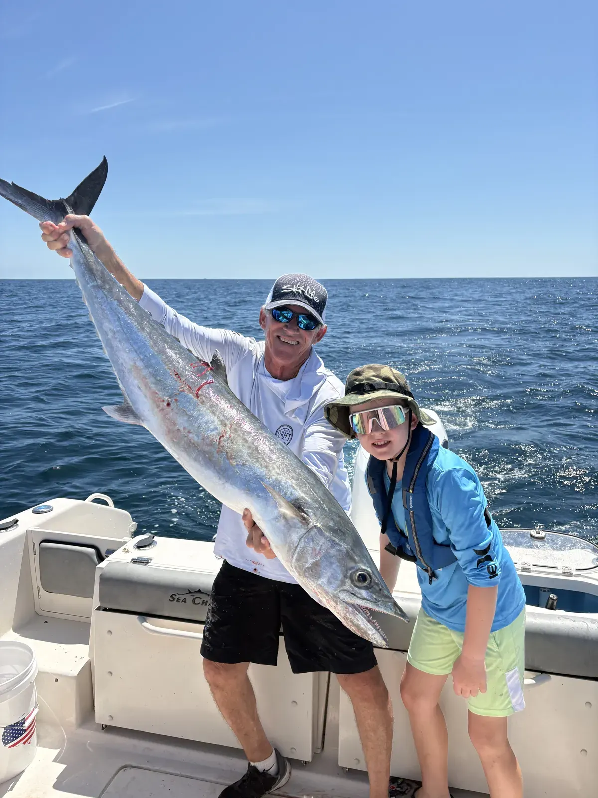 Bo Freidl beside his world-record king mackerel aboard a boat.