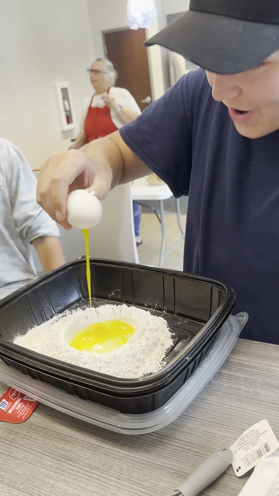 A camper adds an egg to flour for the camp fish fry.