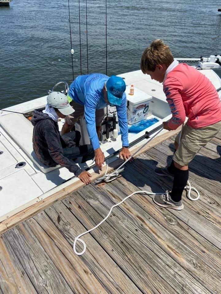 Captain showing campers how to tie a dock line to a cleat