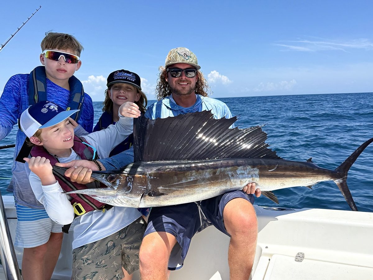 Capt. Roland Bell and three campers with a sailfish