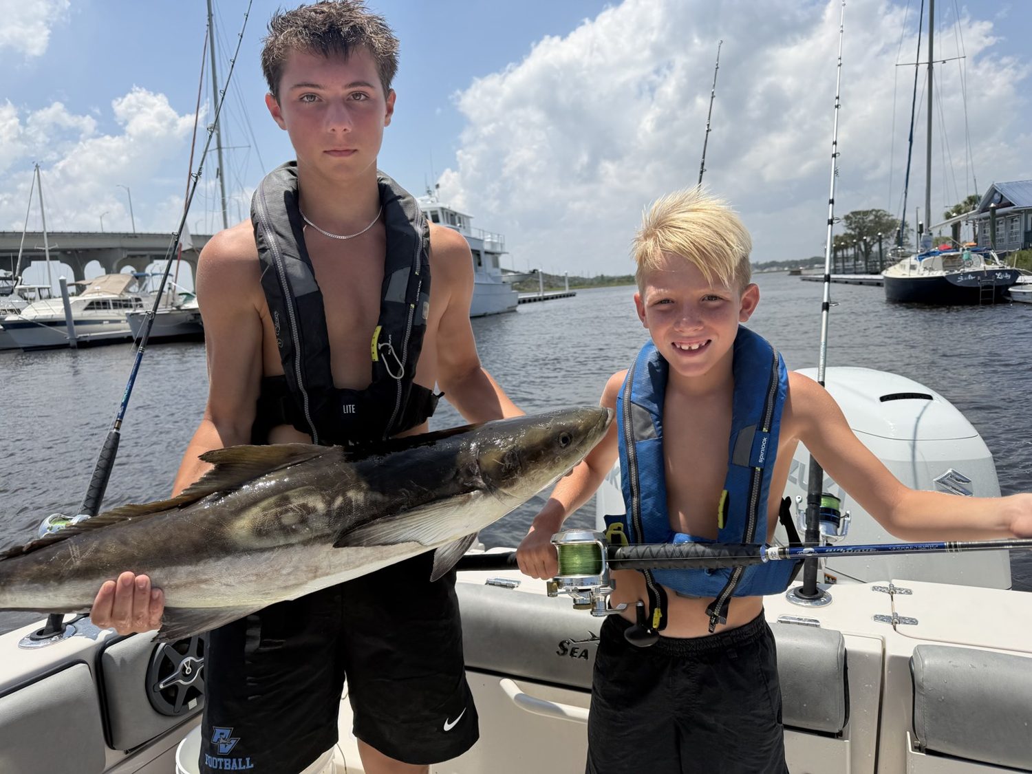 Two advanced campers holding a cobia