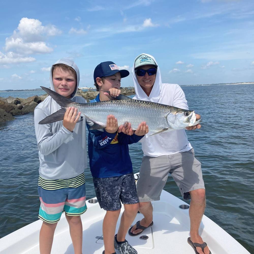 Advanced campers and counselor holding a tarpon