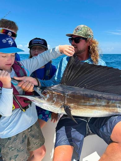 Camper holding a sailfish