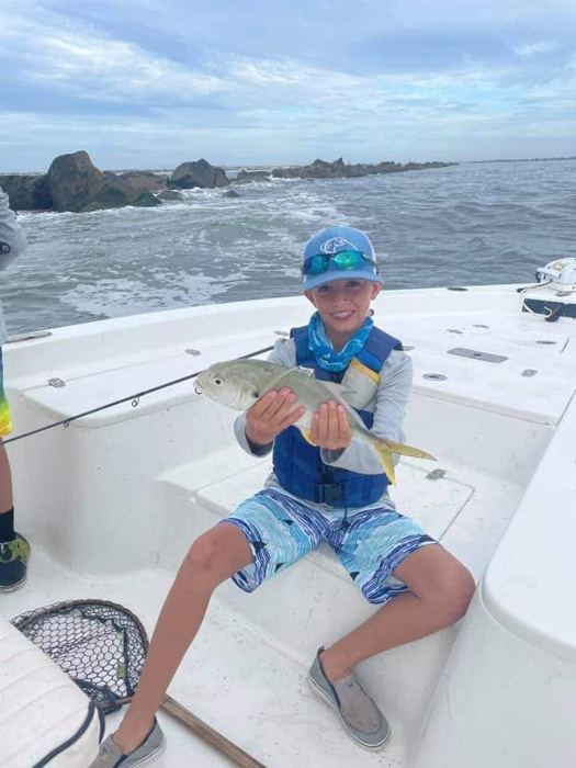 Camper with a jack crevalle by the jetties