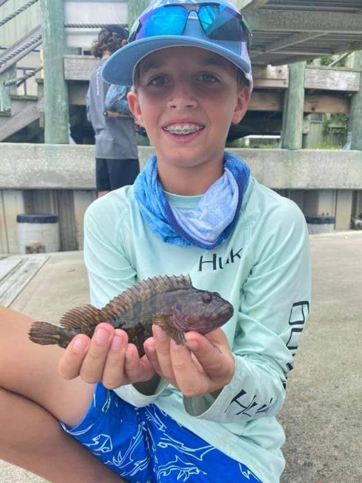 Camper holding a toadfish at the dock